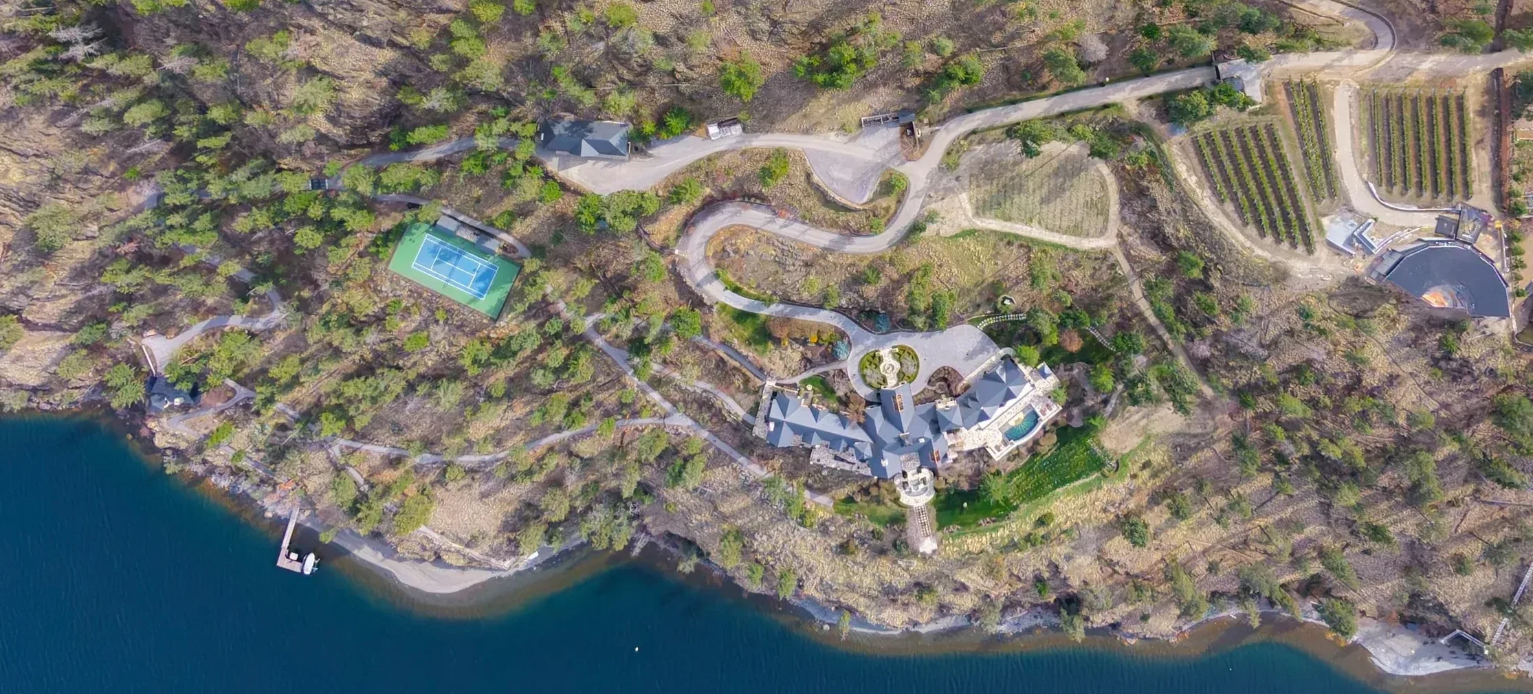 Aerial view of the Château Okanagan estate on Okanagan Lake, showing the Grand Residence, the Estate Villa, the vineyards and the private shoreline