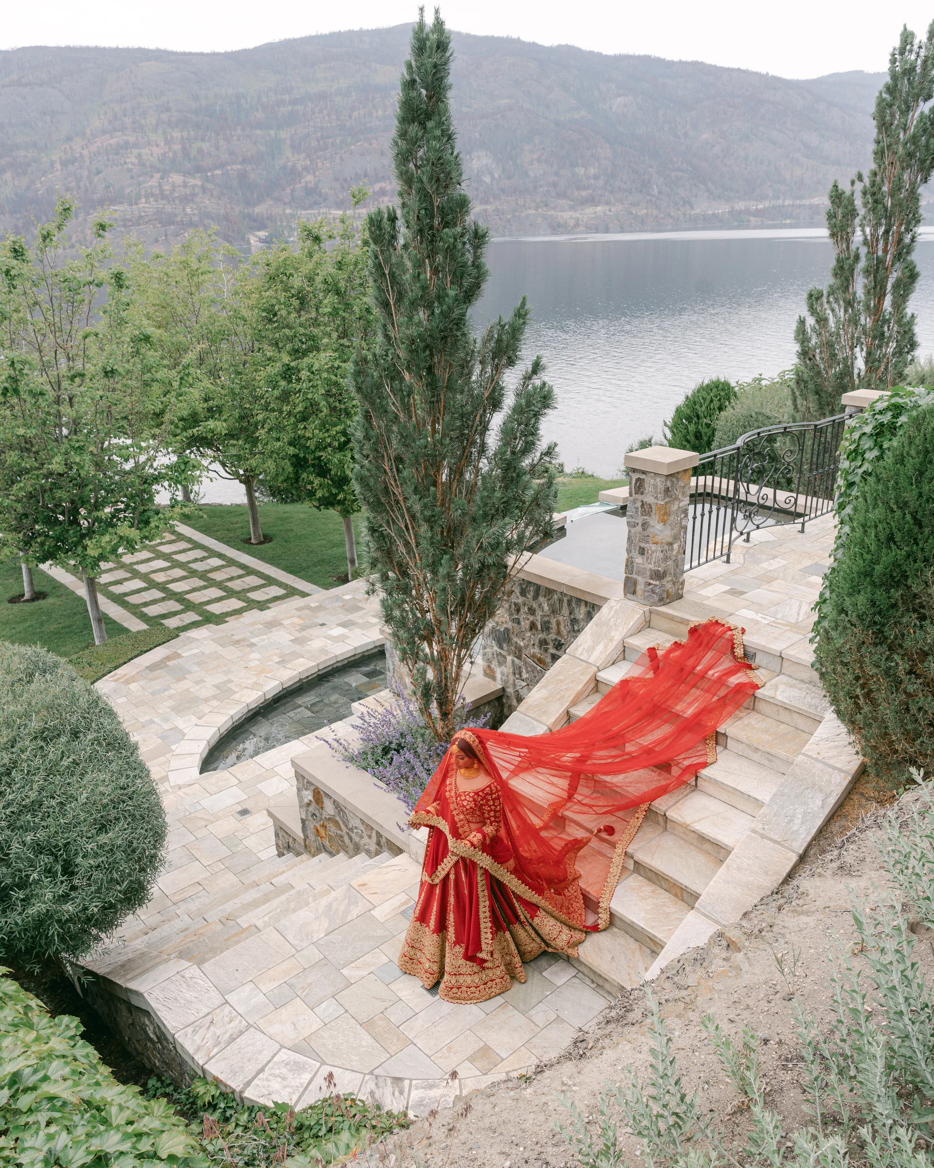 Bride on the terrace steps overlooking the lake at Château Okanagan
